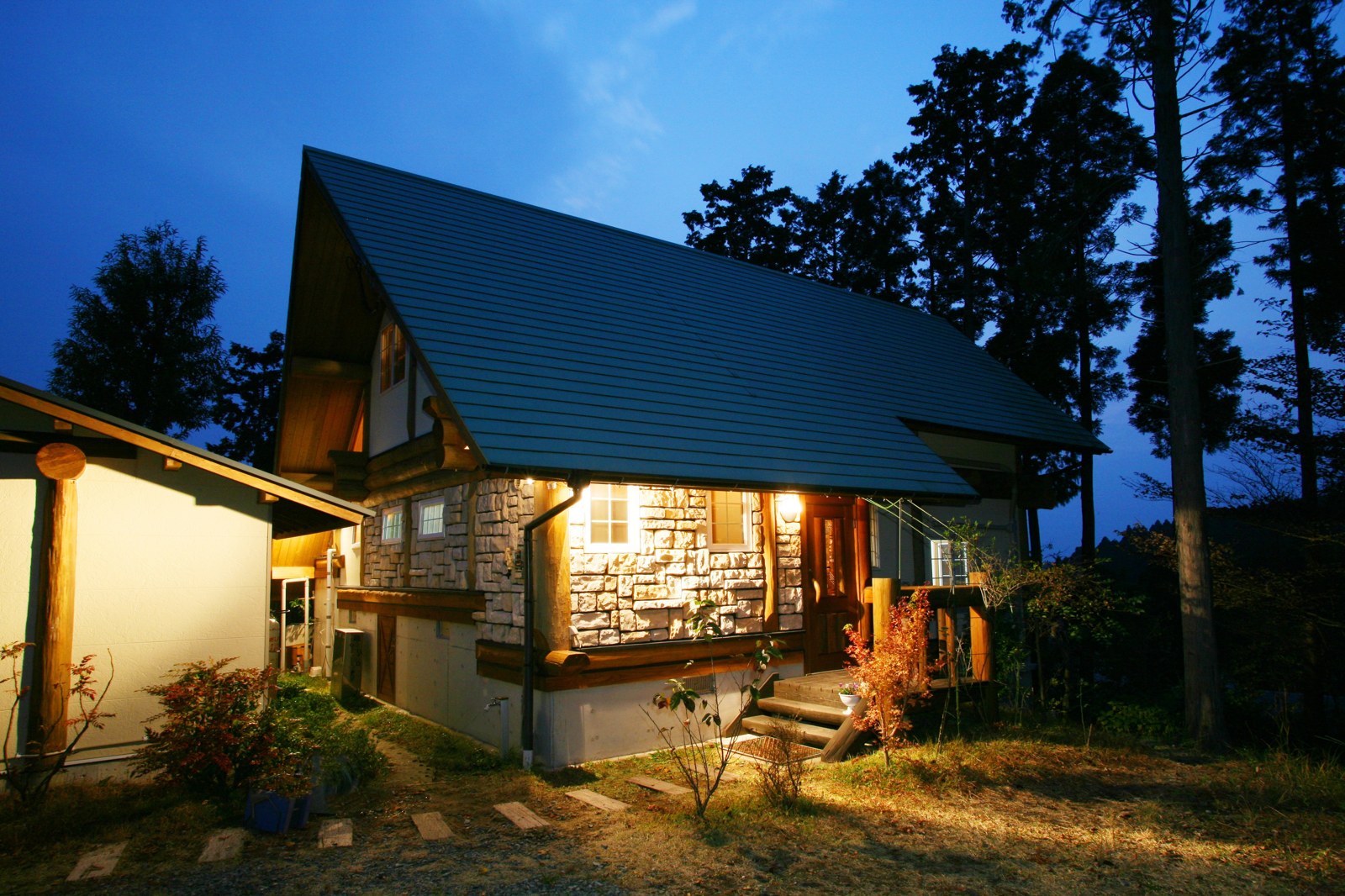 夕暮れに明かりが灯る黒川 森のコテージ